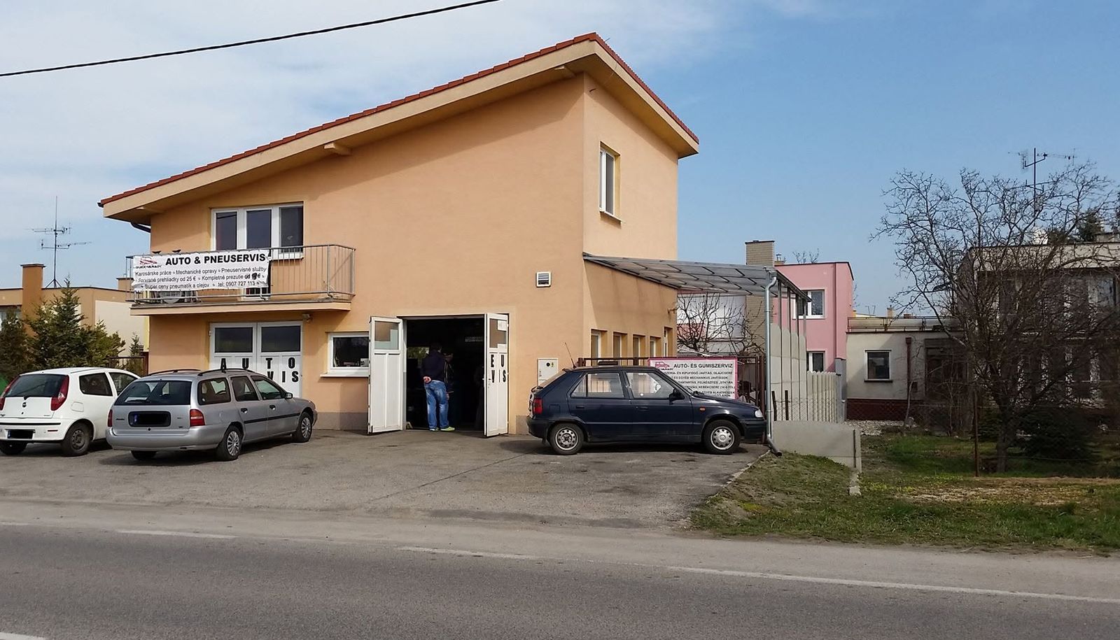 Budova autoservisu QV Cars na Bratislavskej ceste s otvorenou bránou dielne a bannerom Auto a pneuservis